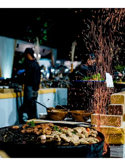 The sizzle and aroma of a live tawa station adds an unforgettable element to any event. This dramatic shot captures the excitement as our chefs prepare succulent kebabs, creating a multi-sensory experience for your guests.