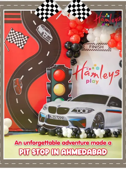 An unforgettable adventure made a pit stop in Ahmedabad! This photo shows the fantastic setup for our Mini Racers event, complete with a racetrack backdrop and traffic light decorations.