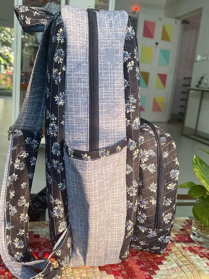 A side view of the organizer backpack, detailing the deep side pockets and sturdy strap construction.