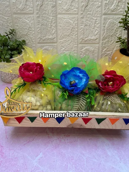Another one of our budget friendly dry fruit hampers for Diwali. This pinewood tray holds three potlis filled with dry fruits, decorated with colorful flowers and a 'Happy Diwali' cutout.