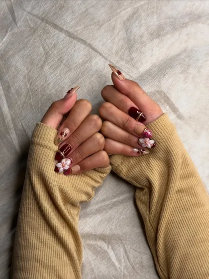 A full view of the hands, showcasing the cohesive yet varied nail art design across the entire set.