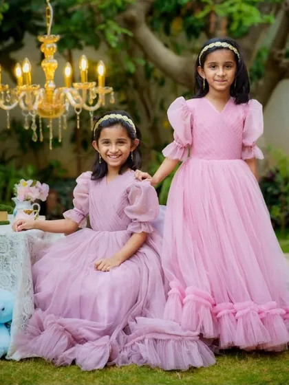 I designed these matching pink gowns for two sisters. The dresses are made with soft tulle and feature puff sleeves and ruffled hems, making them comfortable for kids to wear.