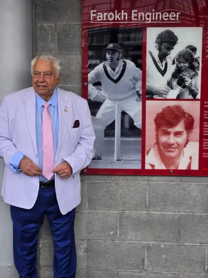 The great Farokh Engineer standing next to the plaque honoring his contributions to the game.
