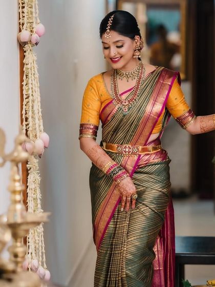 A full-length view of Akanksha's engagement look, showing the beautiful drape of her striped green and pink Kanchivaram saree.