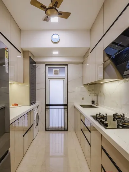 A completed parallel kitchen with a laminate acrylic design. The combination of light-colored cabinets and a marble-patterned backsplash creates a bright and modern cooking environment.