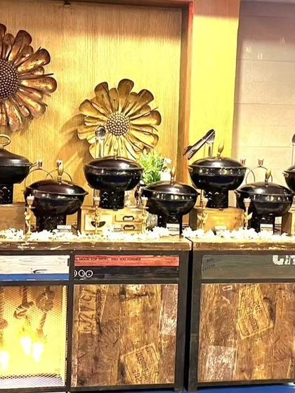 A slightly different angle of the rustic buffet setup, showing the metallic sunflower wall decor. This demonstrates how I integrate my setup with the event's overall design.