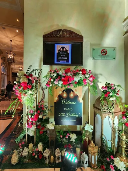 The Sufi Night welcome sign, illuminated by soft, colorful lights. The surrounding lanterns and floral arrangements create a beautiful first impression for guests as they arrive.