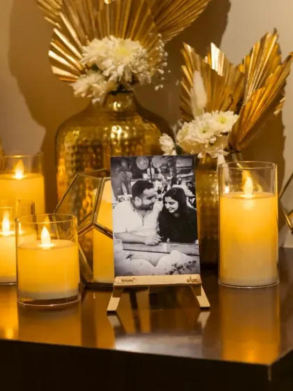 Another detail from the home Roka. A cherished photo of the couple is highlighted by golden decor elements and an array of candles in geometric holders, adding a touch of modern elegance.