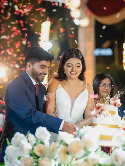 A celebratory moment as the couple cuts their cake. The bride's makeup, featuring shimmery eyes and a glowing complexion, looks just as fresh and perfect at the reception.