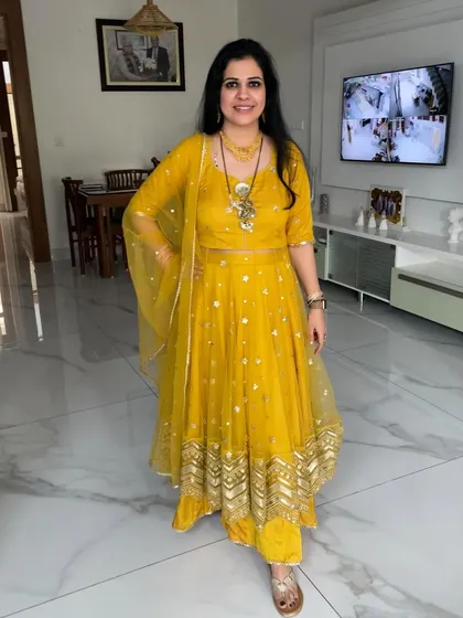 This bright yellow Anarkali with gota patti work was once a net saree. It’s a perfect example of how to create a festive outfit for events like Haldi or Mehendi from your old wardrobe.