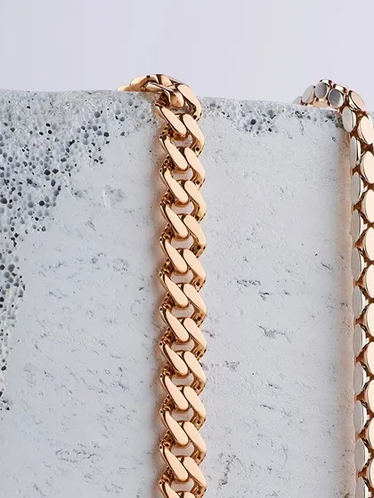 Gold chains and concrete blocks. A study in contrasts. This minimalist shot for Mohini focuses on the texture and form of the gold chains against a rough, industrial-style block.