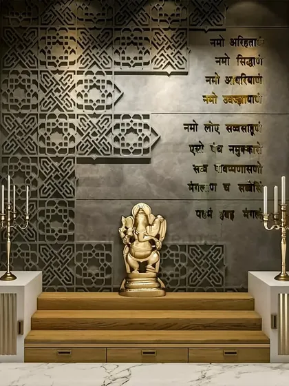 I designed this pooja room to be a tranquil and modern sacred space. The design features intricate jaali work on a concrete-finish wall, with elegant gold lettering of the Navkar mantra and a Ganesha idol on a raised wooden platform, creating a peaceful corner for prayer.