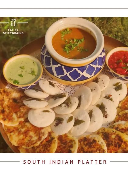A delightful South Indian Platter with mini idlis and uttapams, served with authentic sambar and chutneys in traditional ceramic bowls.
