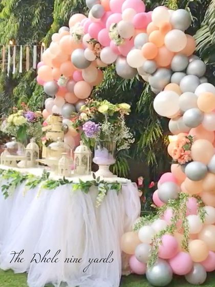 A dreamy boho-chic dessert table framed by a pastel balloon arch. The tulle table skirt and soft colors created a whimsical and gentle atmosphere for the celebration.