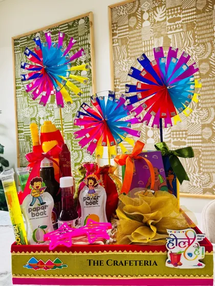 A full view of the nostalgic Holi hamper. It's a burst of joy, featuring a sweet box wrapped in organza, a potli of dry fruits, thandai, sherbet, and fun quirky glasses, all packed into a festive tray that screams 'Holi Hai!'.