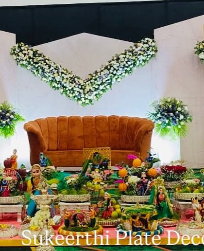 This puberty ceremony setup in Annur features a modern stage design. My traditional platter arrangements in the front provide a beautiful contrast and a connection to our culture.