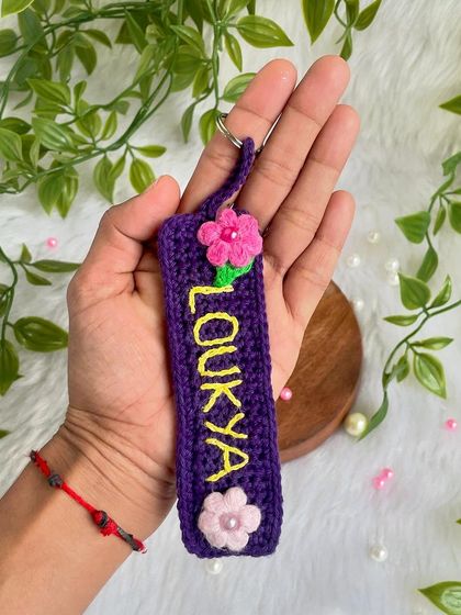 Holding the personalized name keychain to show its size. It's a thoughtful and unique gift for someone special.
