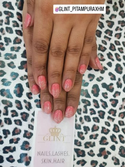 This manicure features a lovely coral-pink base with a delicate dusting of fine silver glitter fading from the cuticle. It's a soft and feminine look with just the right amount of sparkle.