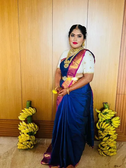 A full-length shot of the bride, ready for her Baleshastra ceremony. The traditional decor with banana leaves adds to the festive atmosphere.