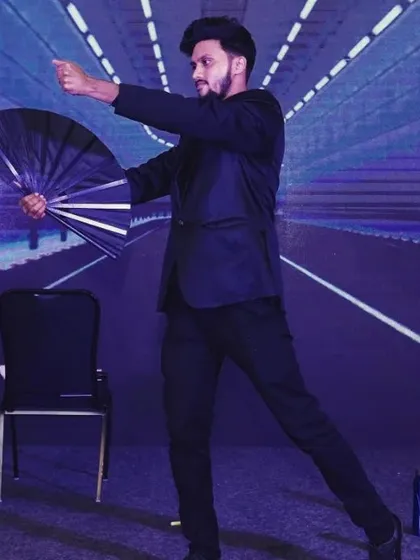 This is me in my element, performing on stage with a classic fan manipulation routine. A dynamic stage presence is key to holding the attention of a large audience, and I use a mix of classic and modern magic to create a visually stunning show for conferences and galas.