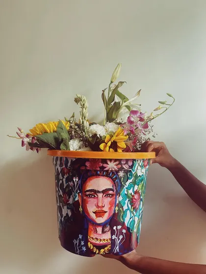 A different view of the Frida Kahlo planter, showing how the artwork looks in a different light. The piece is designed to be a captivating centerpiece filled with flowers or a plant.