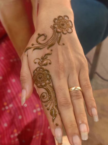 This minimalist design features a beautiful floral trail on the back of the hand. The combination of a mandala and flowing vine creates a simple yet captivating look.