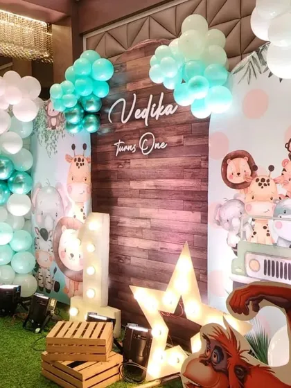 A detailed look at the decor, showing the light-up number '1', a star marquee light, and a backdrop featuring a group of cute safari animals in a jeep.
