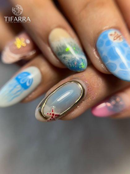 A detailed look at an ocean-themed nail with a 3D effect, featuring a tiny starfish and a gold chrome border.
