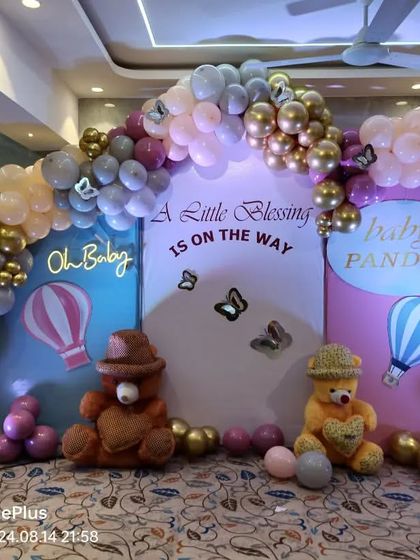 A full view of the teddy bear and hot air balloon themed baby shower decoration. The setup includes 'BABY' blocks and soft lighting to create a warm and welcoming atmosphere.