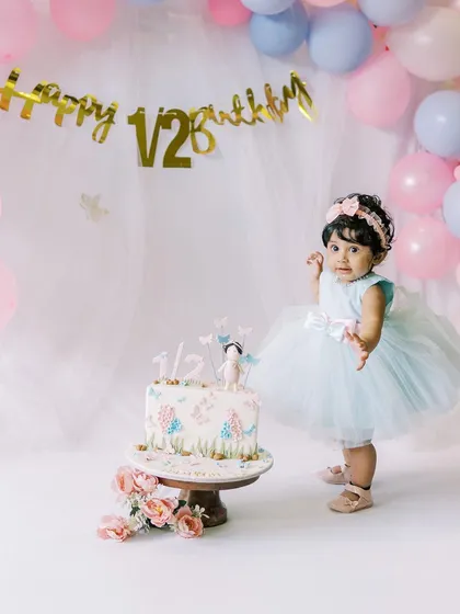 A half-birthday celebration for a sweet baby girl. The cake is almost as big as she is.