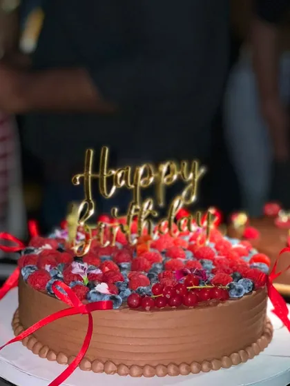A side view of Kanika Kapoor's birthday cake, showing the rich chocolate frosting and abundance of fresh berries.