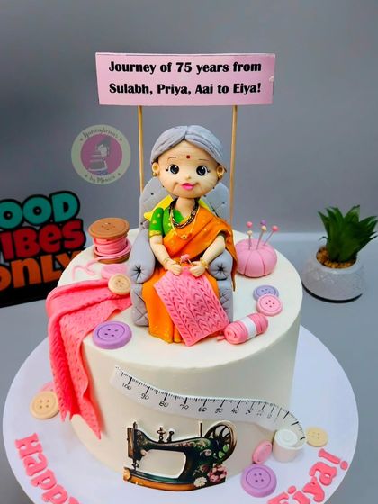 A 75th birthday cake for a mom who loves knitting and sewing, featuring a detailed figurine and all her crafting tools.