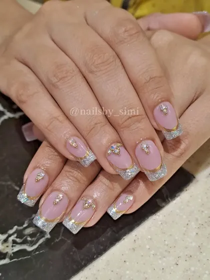 A full bridal look! This set combines glitter French tips with gold chrome lines and carefully placed jewels for a glamorous and cohesive wedding design.
