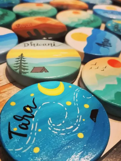 An assortment of our travel-themed magnets, showing the variety of scenes we can create, including starry nights over a campsite and sunsets over the forest.