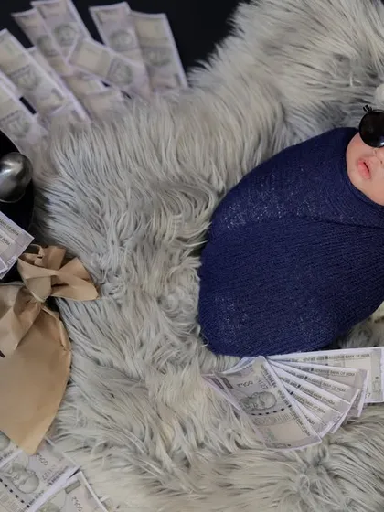 Another angle of the "Money Heist" theme, showcasing the full setup with bags of money and fanned-out notes on a plush grey fur rug.