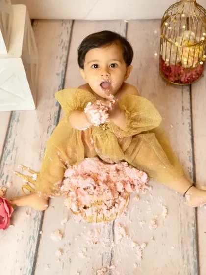 An overhead view of the delightful mess. This angle shows the full extent of the fun, with cake and frosting creating a playful scene around the happy baby.