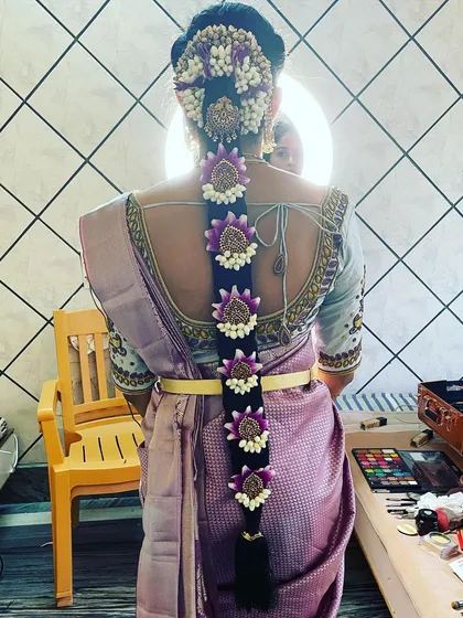 A beautiful hairstyle completes the entire look. This is an example of a traditional South Indian bridal braid, intricately woven and decorated with fresh flowers for a classic and elegant finish.