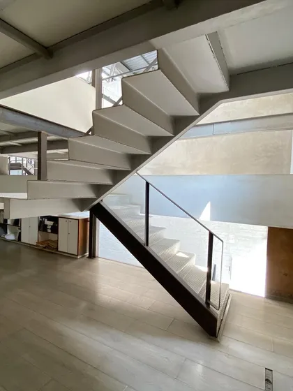 A different view of the staircase at Zanav Home, showing how it connects different levels of the open-plan studio.