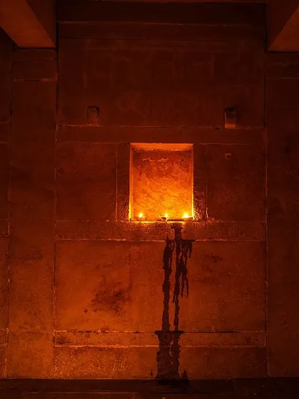 The simple beauty of Dev Deepawali, with diyas placed in the niches of an old stone wall on the ghats, their warm glow creating a serene and meditative atmosphere.