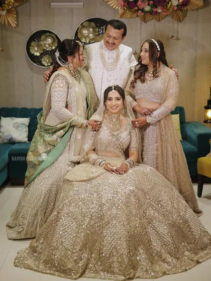 A beautiful family portrait with the bride at the center, surrounded by her loving family in coordinated outfits. A candid moment of interaction.