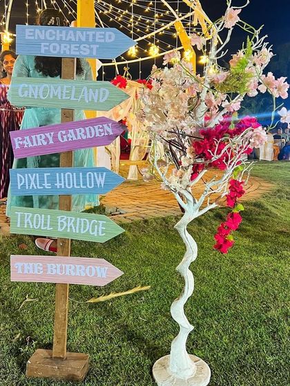 A fun and creative signpost for the enchanted forest party, with arrows pointing to magical places like 'Fairy Garden' and 'Pixie Hollow'.