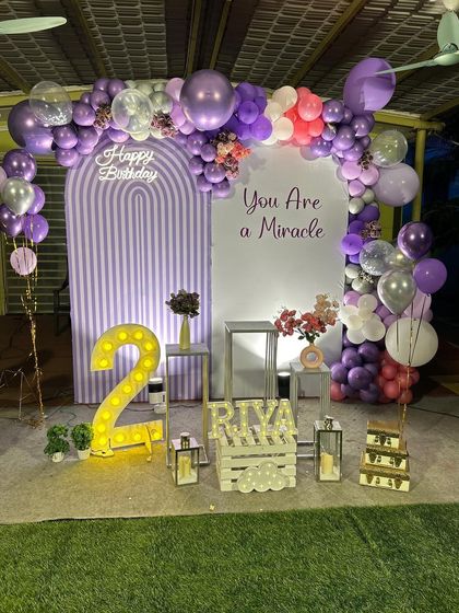 Another view of the lavender-themed second birthday setup. The arrangement of props, including lanterns and floral displays, adds depth and elegance to the overall party decor.