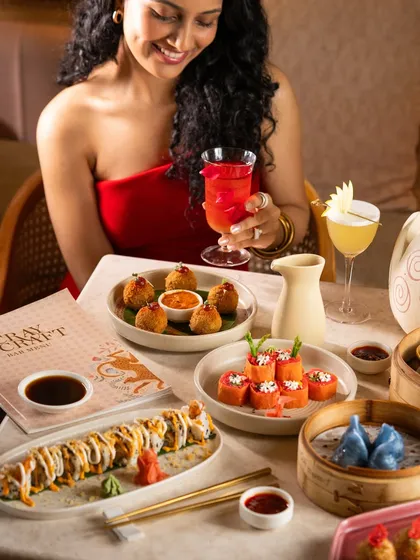A stylish woman enjoying a meal and a cocktail. This creates an aspirational vibe, associating the restaurant with elegance and fun.