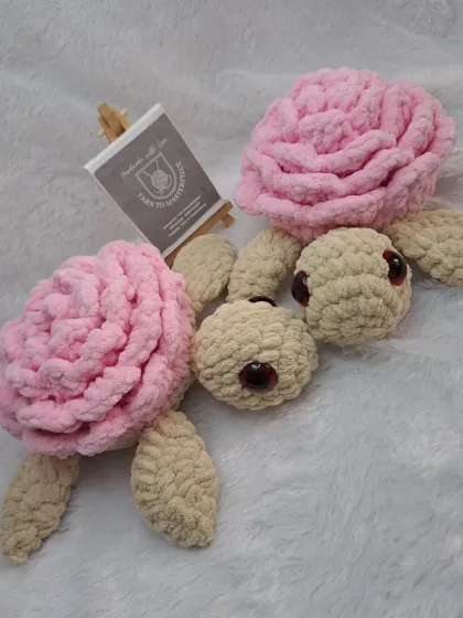 Two plush rose turtles, showing a close-up of the safety eyes I use to make them child-friendly.