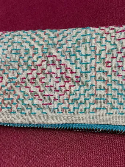 The finished zippered pouch, perfect for carrying spectacles, a phone, or other small essentials. The fabric tassel adds a final handmade touch.