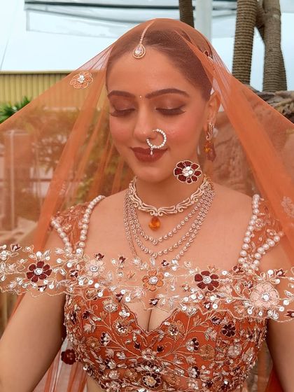 A beautiful, soft-focus shot through the veil. The makeup looks ethereal and dreamy, perfect for romantic wedding portraits.