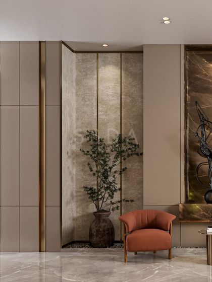 This detail shot shows the interplay of materials in a common area, with paneled walls, brass inlays, and a small plant in a textured niche. An orange armchair adds a pop of color.