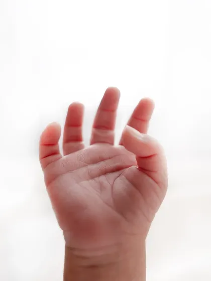 A tiny, perfect hand reaching out. I focus on capturing these small but significant details during my newborn photography sessions.