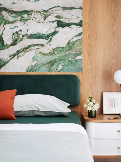 I love using bold, natural materials to make a statement. Here, a luxurious slab of Botanic Garden marble serves as a stunning backdrop, complemented by an emerald green headboard for a touch of organic luxury.