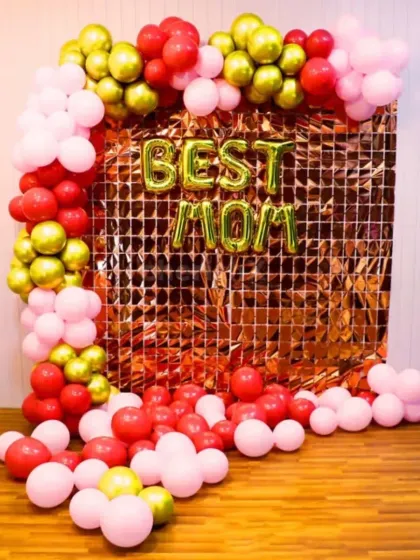 A 'Best Mom' decoration with a rose gold shimmer backdrop and a red, pink, and gold balloon frame.